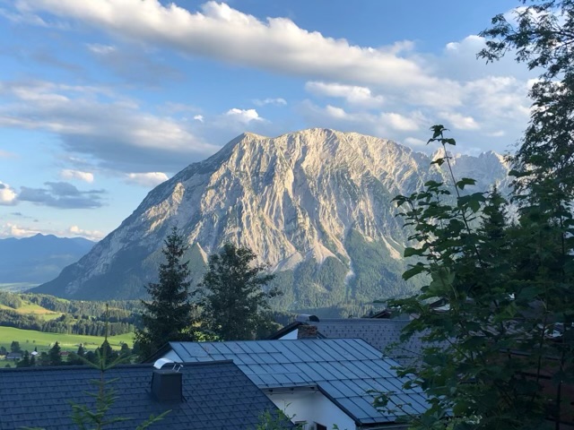 Evening sun warming the face of the Grimming, the roofs below in shadow
