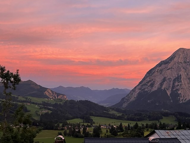 A pink sunset over the valley, the Grimming dark against the sky